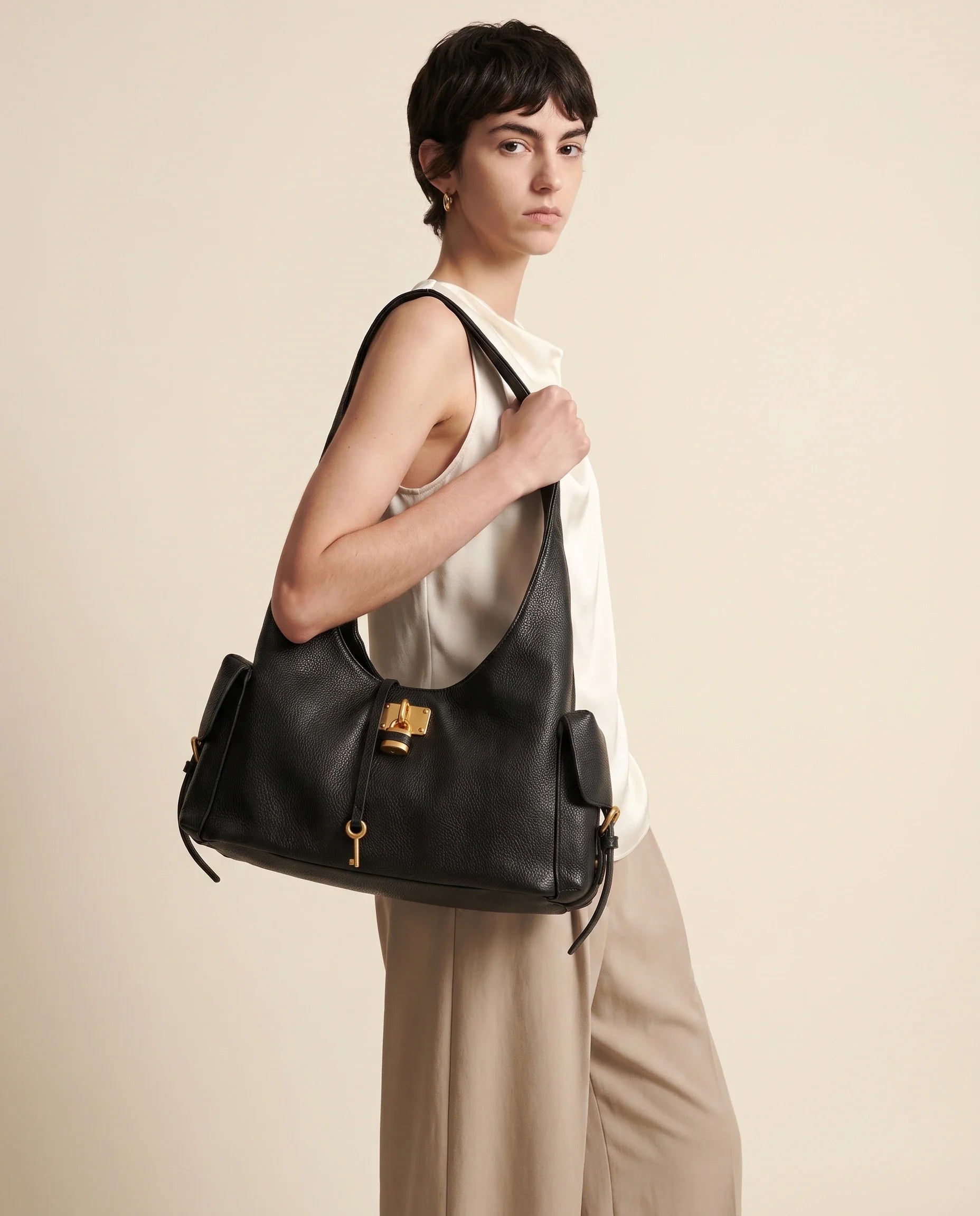 Black Leather Structured Shoulder Bag with Lock Detail in Black — worn by model