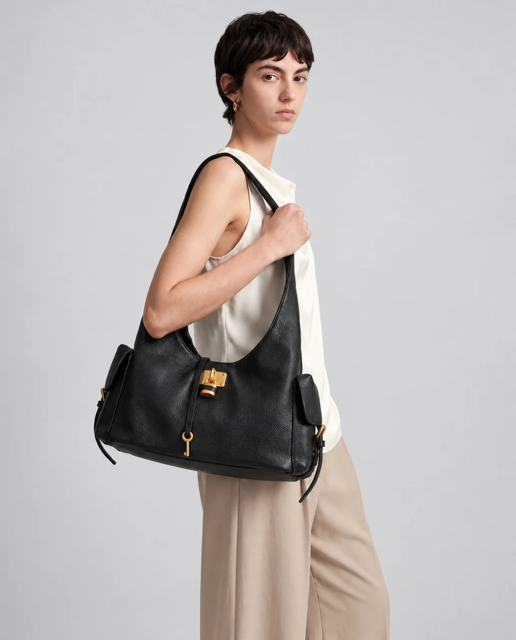 Black Leather Structured Shoulder Bag with Lock Detail in Black — worn by model