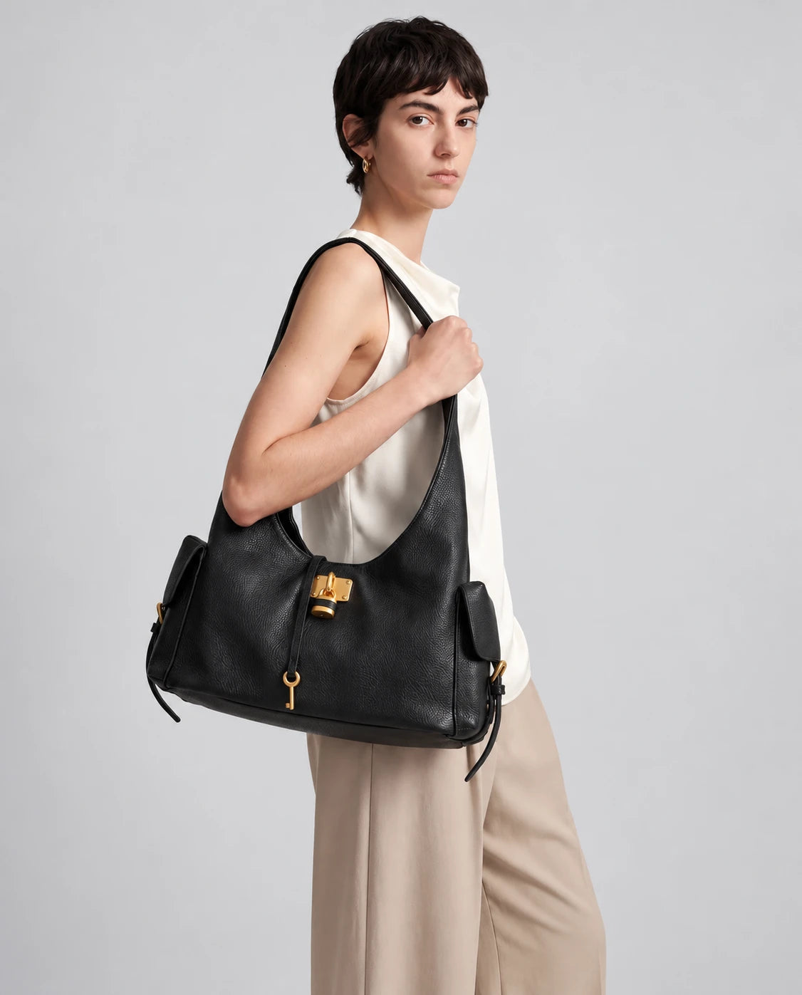 Black Leather Structured Shoulder Bag with Lock Detail in Black — worn by model